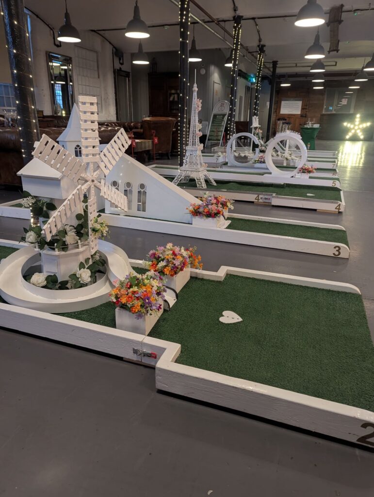 Luxury wedding crazy golf course with windmill and chapel holes set up indoors for an evening reception
