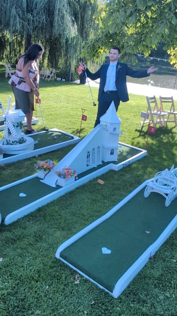 A wedding guest celebrating a hole-in-one on the crazy golf course at Barns & Yard