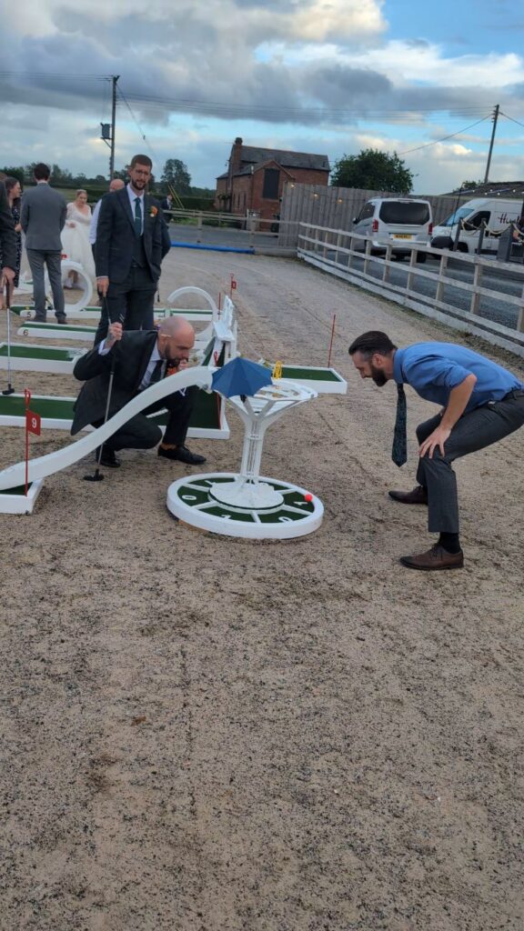 A guest lining up a putt on the wedding crazy golf course at Burlton Manor