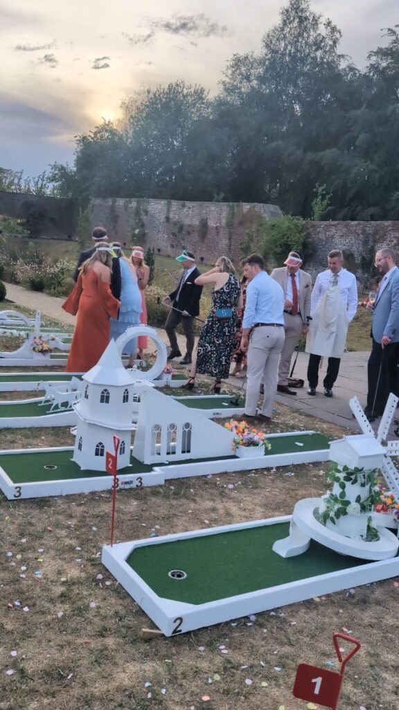 Wedding guests playing crazy golf in the walled garden at Foxtail Barns at sunset