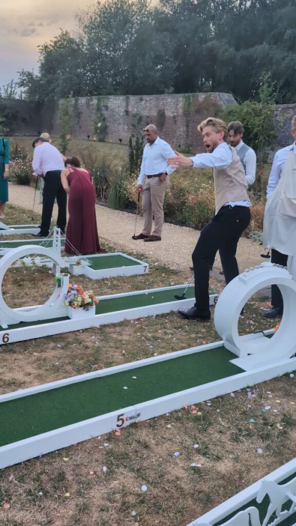 A wedding guest taking a shot on the crazy golf course at Foxtail Barns