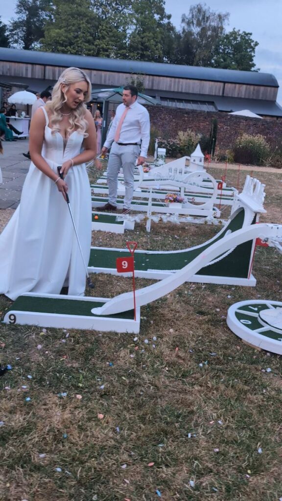 Bride playing wedding crazy golf in the 18th-century walled garden at Foxtail Barns, Staffordshire