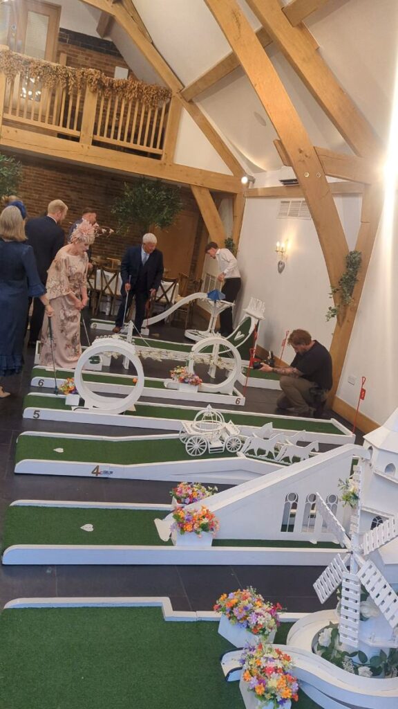 Indoor wedding crazy golf beneath the gallery at Mythe Barn, Leicestershire