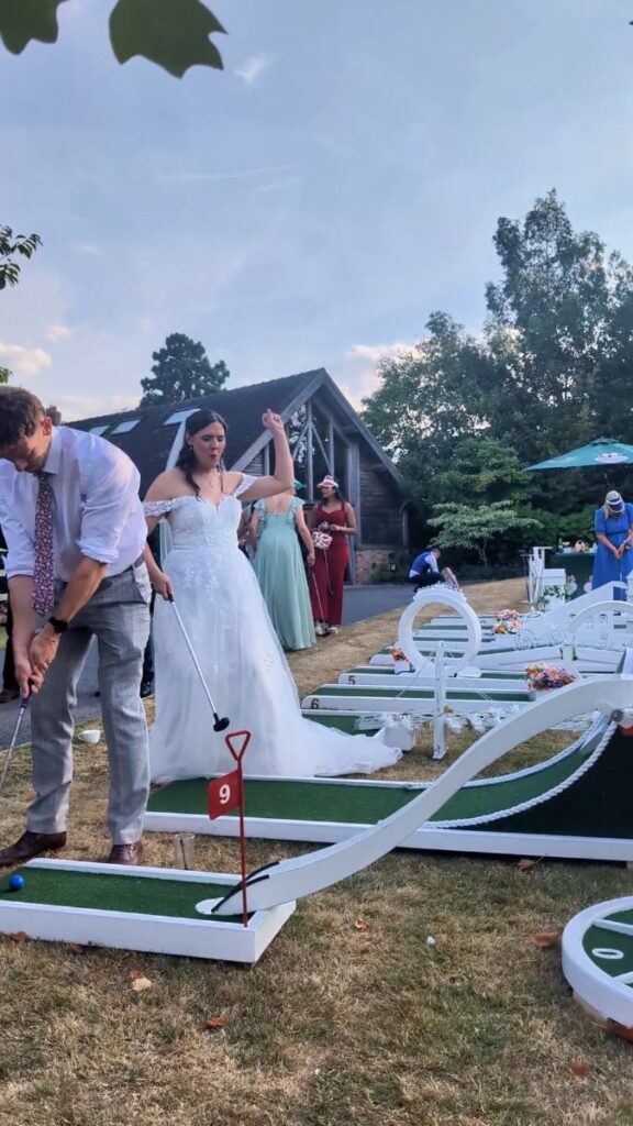 Wedding guests playing crazy golf on the lawn at Mythe Barn, Sheepy Magna