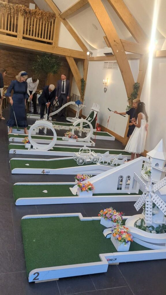 Guests playing wedding crazy golf inside the barn at Mythe Barn