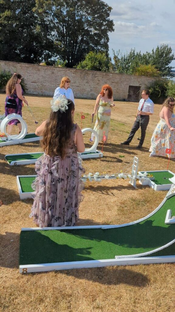 A wedding guest playing crazy golf at Normanton Park Gardens