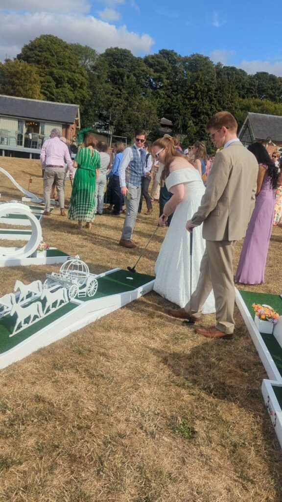Bride and groom playing wedding crazy golf on the lawn at Normanton Park Gardens, Rutland Water