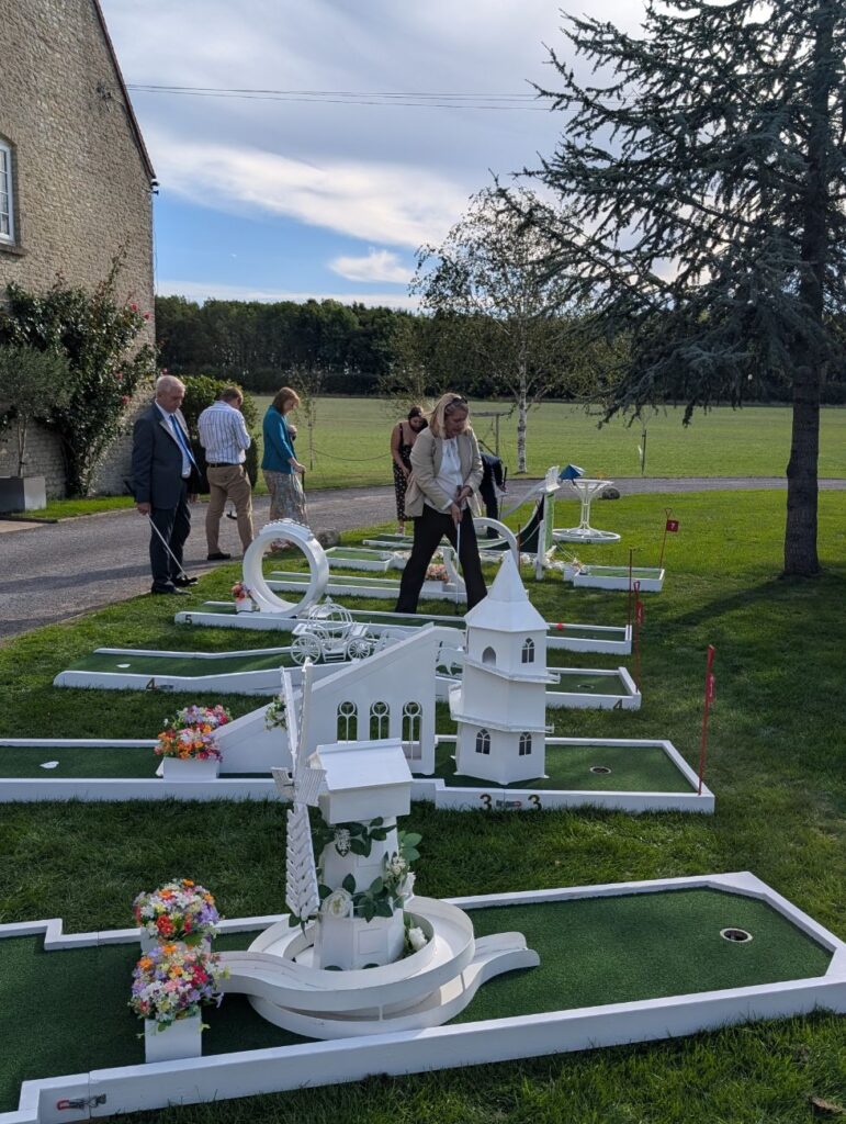 Wedding guests playing crazy golf on the lawn at Stratton Court Barn, Oxfordshire