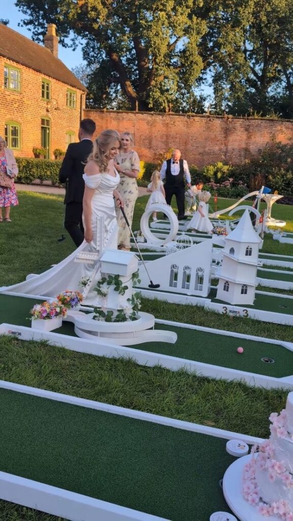 Bride and guests by the crazy golf course in the walled garden at Thorpe Garden
