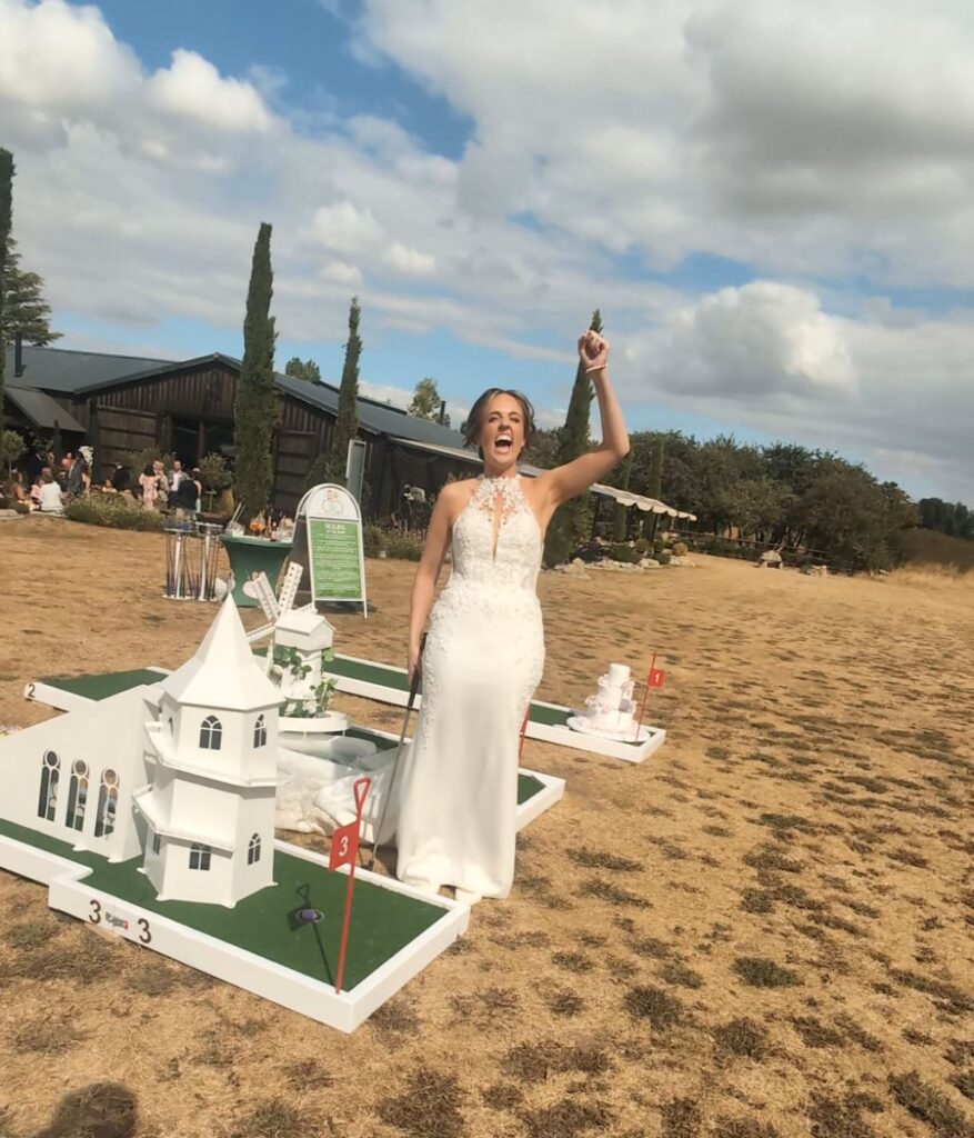 Bride celebrating on the wedding crazy golf course at The Willow Marsh Farm, Nottinghamshire